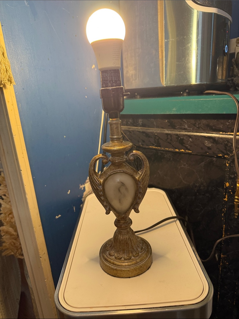 Vintage decrative table lamp featuring an urn shaped silhouette with double scro